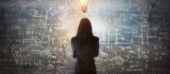 Young woman looking on the black board with mathematical formulas and calculations. Bright idea, way of thinking, discovery and challenge concept.