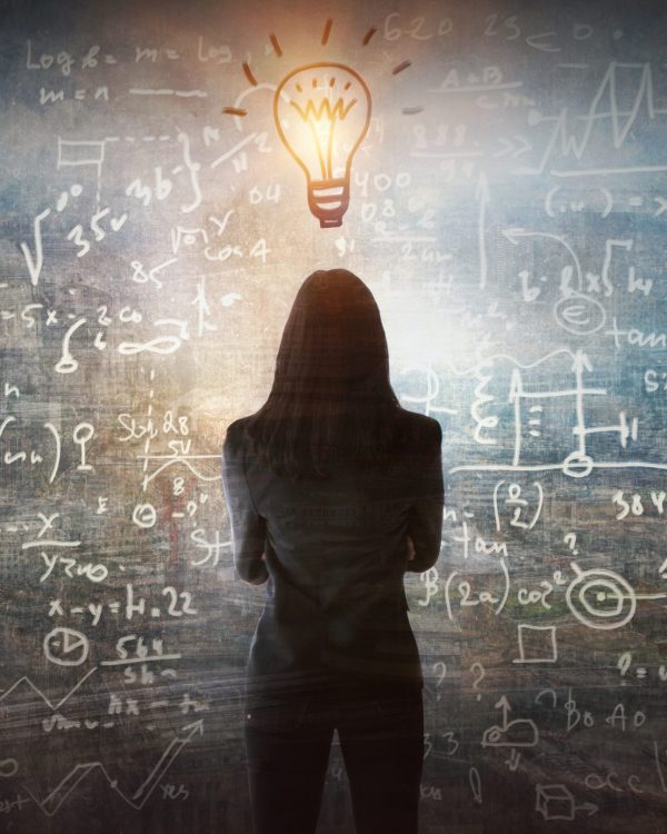 Young woman looking on the black board with mathematical formulas and calculations. Bright idea, way of thinking, discovery and challenge concept.